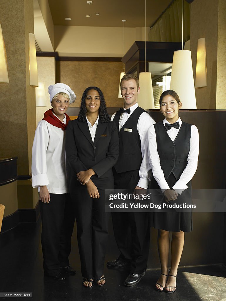 Four hotel employees, smiling, portrait