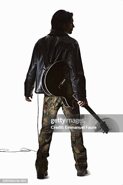 young man holding guitar, rear view - gitarrist stock-fotos und bilder