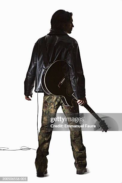 young man holding guitar, rear view - gitarist stockfoto's en -beelden