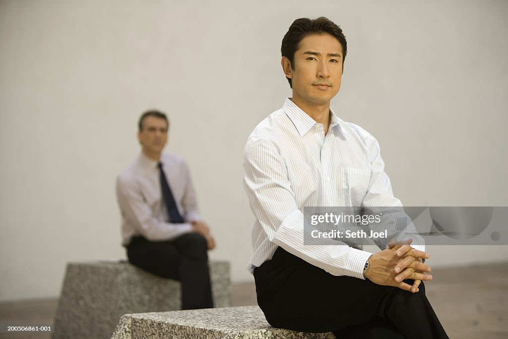 Businessmen sitting outside, portrait