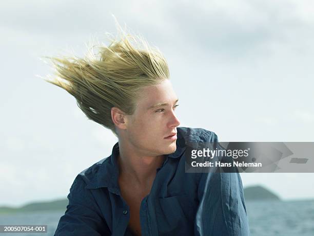 young man outdoors, hair blowing in wind - despeinado fotografías e imágenes de stock