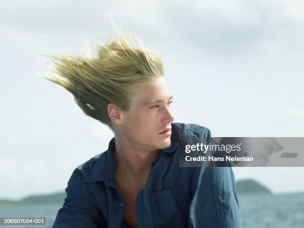 young man outdoors, hair blowing in wind - cheveux dans le vent photos et images de collection