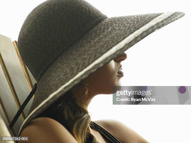 young woman wearing sun hat, side view - adirondack chair white background stock pictures, royalty-free photos & images