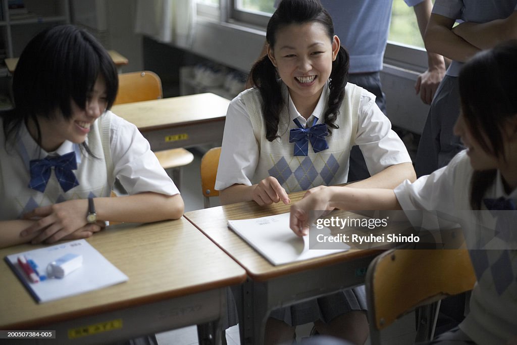 Teenage students (13-18) in classroom, girls laughing