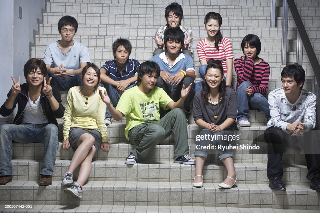 Group of teenagers (13-18) sitting on steps, portrait