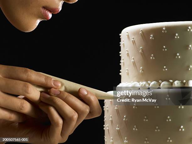 young woman decorating layered cake with icing bag, side view - decorating a cake stock pictures, royalty-free photos & images