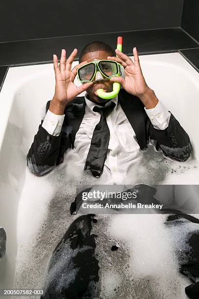 young man in suit and snorkel sitting in bubble bath - een bad nemen stockfoto's en -beelden