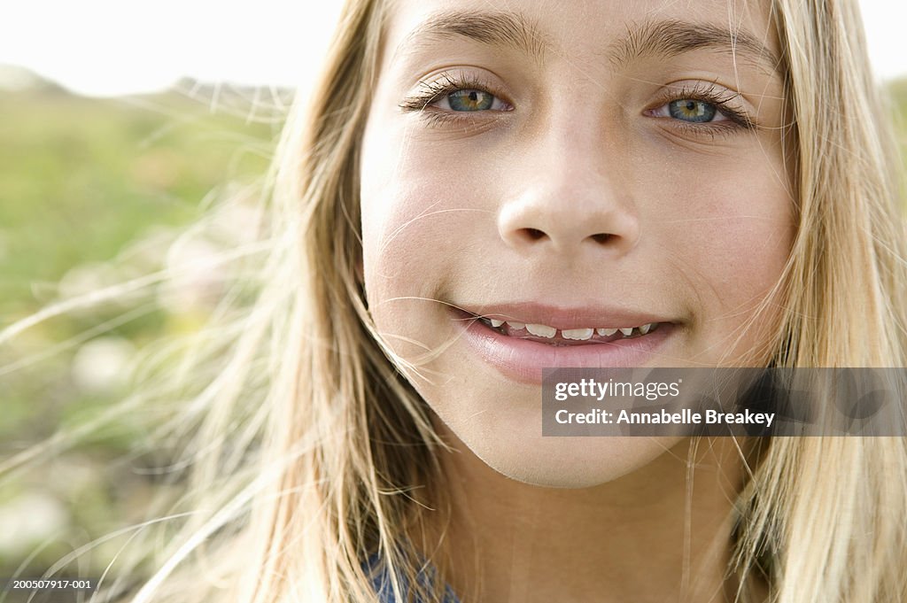 Girl (9-11) smiling in field