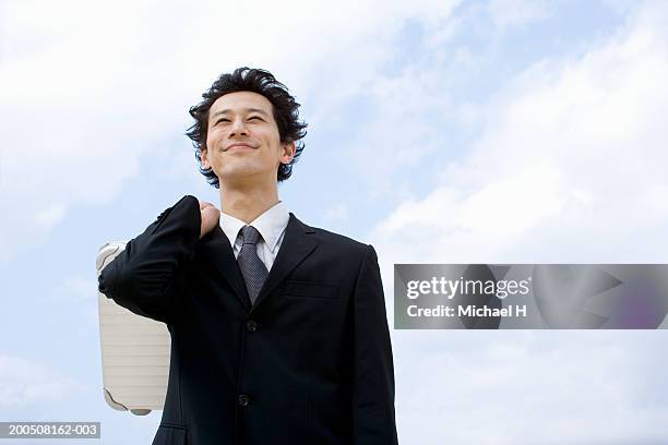 young businessman carrying briefcase over shoulder, smiling - content japanese ethnicity stock pictures, royalty-free photos & images