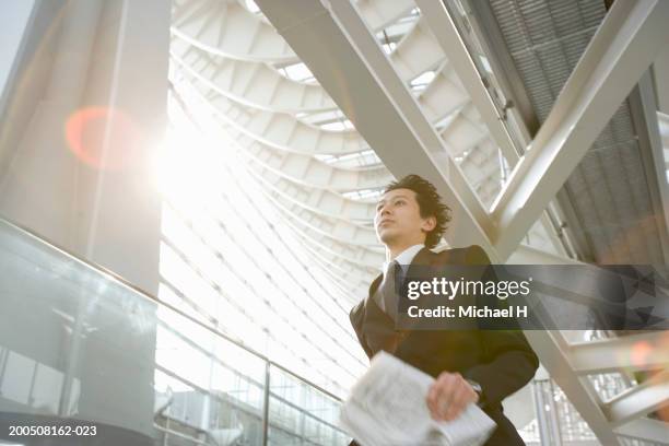 young businessman with newspaper running down corridor - 24 h du mans bildbanksfoton och bilder