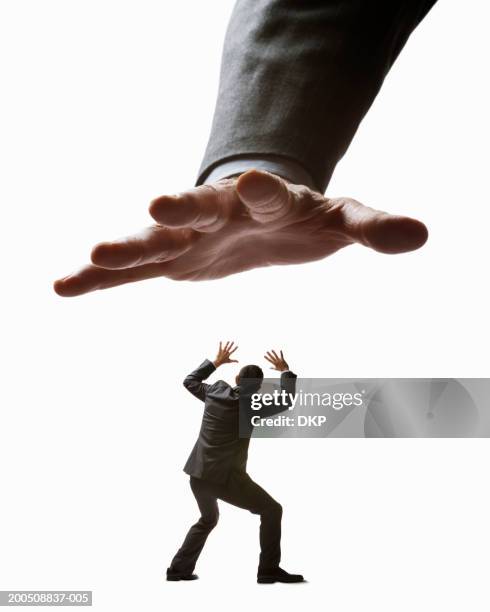 man reaching out to grab young businessman (digital composite) - office politics stock pictures, royalty-free photos & images