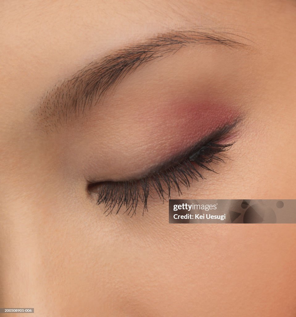 Young woman with eyes closed, close-up of eye