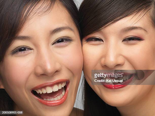 two young women cheek to cheek, laughing, portrait - 若い女性 日本人 顔 ストッ��クフォトと画像