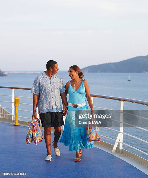 mature couple walking on cruise ship, smiling - river cruise stock-fotos und bilder