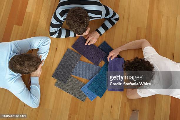 men lying on floor looking at carpet samples, overhead view - carpet samples ストックフォト�と画像