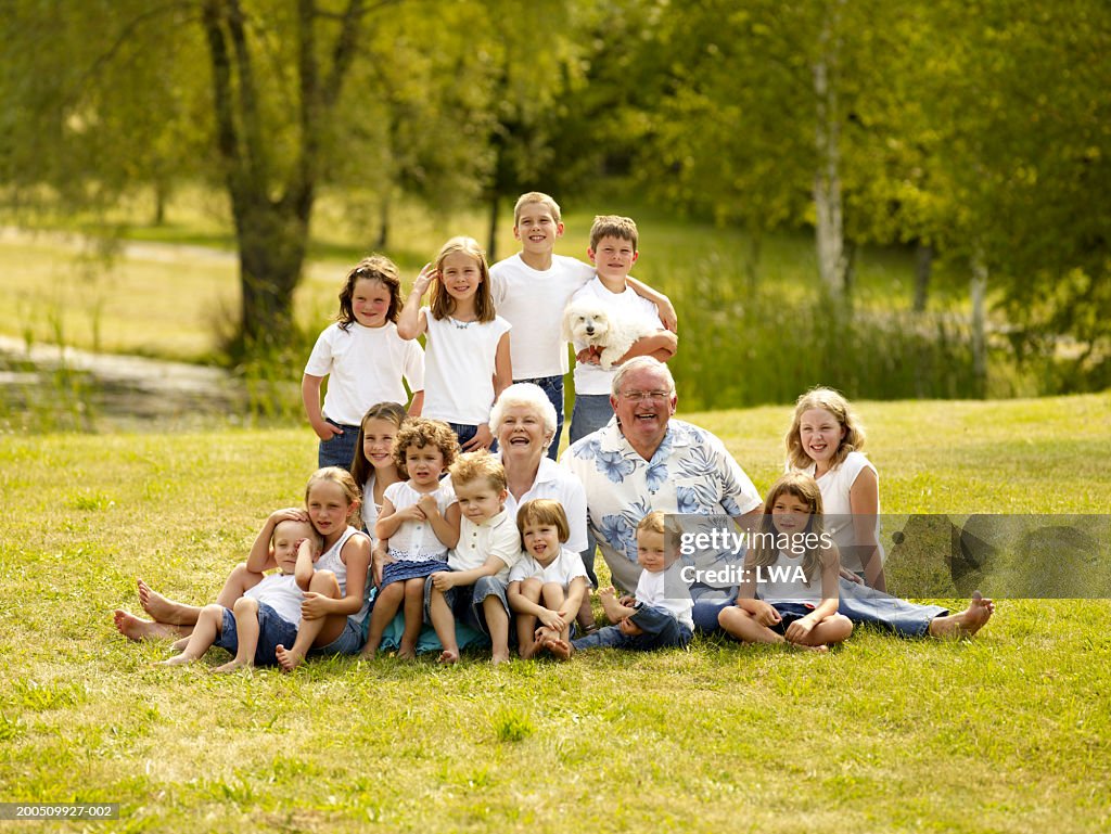 Senior couple with children outdoors, smiling, portrait