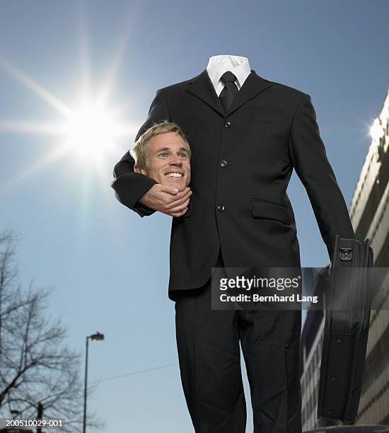 businessman holding head under arm (digital enhancement) - headless stockfoto's en -beelden