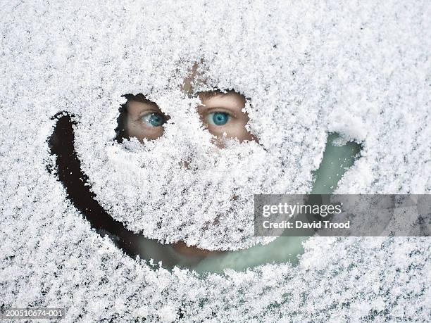 man peeking through snow covered window - funny snow stock-fotos und bilder