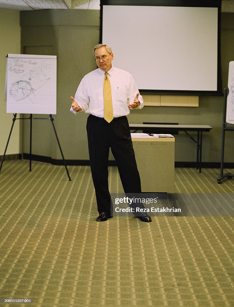 Motivational speaker standing in front of projection screen