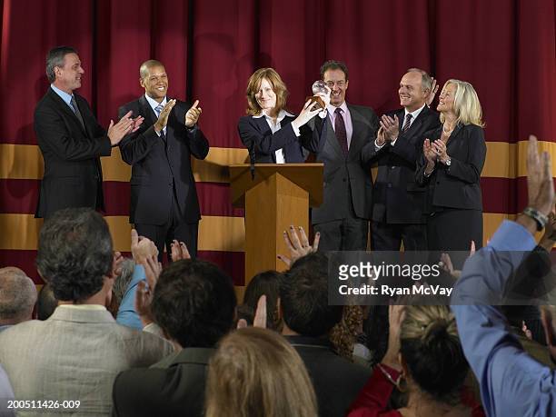 business team receiving award on stage, audience in foreground - awards ceremony stock pictures, royalty-free photos & images