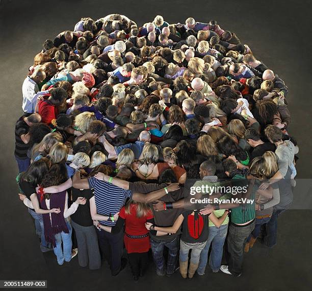large group of people standing in circle with arms around each other - reunión de equipo fotografías e imágenes de stock