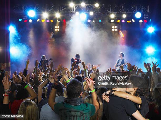 band performing on stage, couple embracing in audience - kiss rock fotografías e imágenes de stock