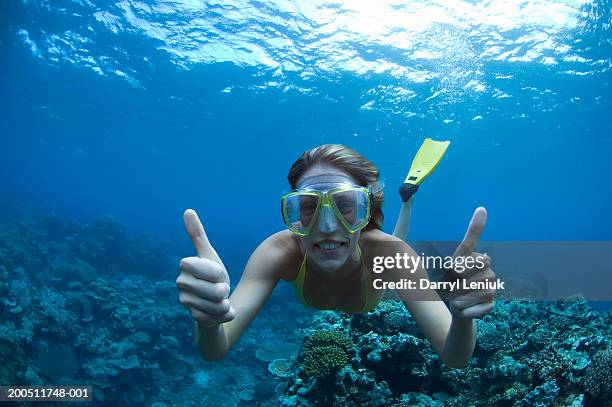fiji, young woman snorkeling, giving thumbs up, underwater view - fiji stockfoto's en -beelden
