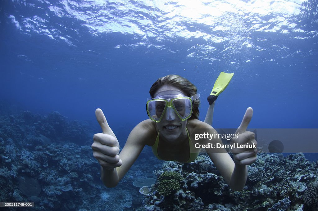 Fiji, young woman snorkeling, giving thumbs up, underwater view