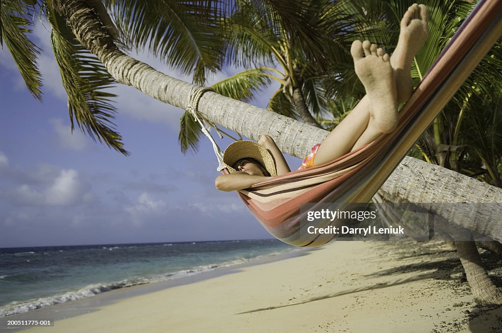 Fiji, Namenalala Island, young woman lying in hammock on beach