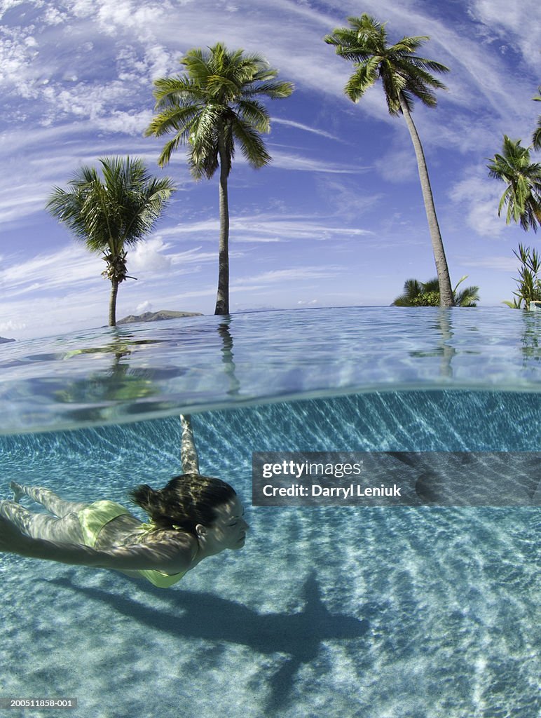 Fiji, young woman swimming in pool, surface view