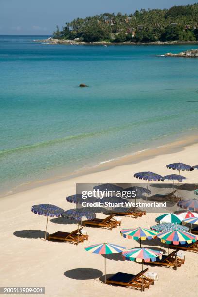 thailand, phuket, lounge chairs and sun umbrellas on surin beach - surin beach stock pictures, royalty-free photos & images