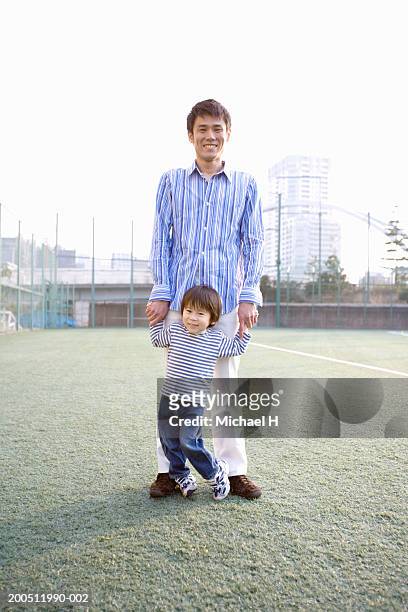 father and son (2-4) standing on soccer field, portrait - 24 h du mans bildbanksfoton och bilder