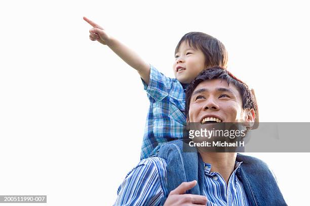 father carrying son (2-4) on shoulders, boy pointing and smiling - cute japanese boy stock-fotos und bilder