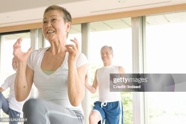 group of senior adults exercising in gym, smiling, low angle view - on one leg stock pictures, royalty-free photos & images