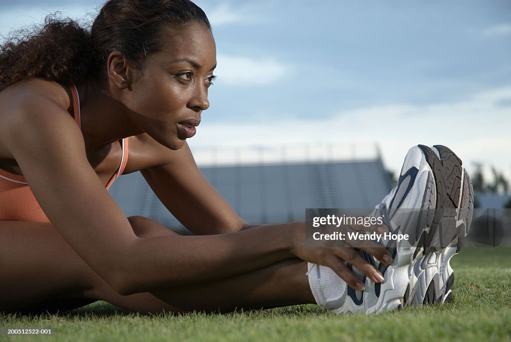 Young woman performing warming up exercises