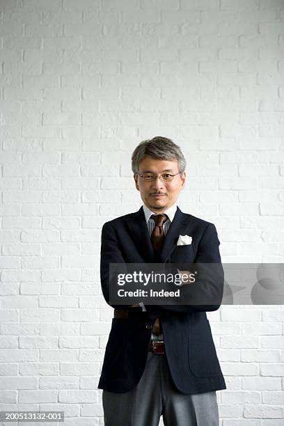 mature businessman with arms folded, portrait - japanese ethnicity the human body stock pictures, royalty-free photos & images