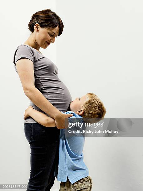 son (2-4) embracing pregnant mother - sandy molloy stock pictures, royalty-free photos & images