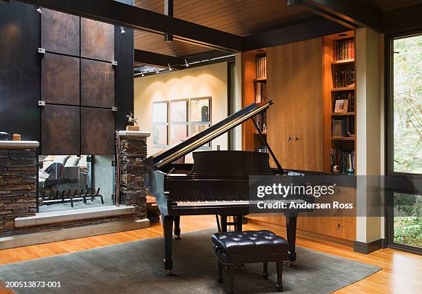 piano beside fireplace in living room - music room stockfoto's en -beelden