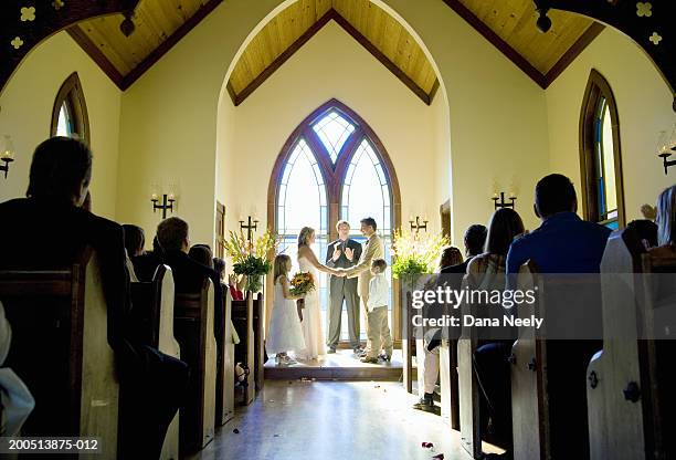 bride and groom getting married during wedding ceremony in chapel - wedding ceremony seating stock pictures, royalty-free photos & images