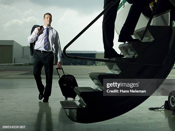 businessmen boarding private plane in hangar - boarding plane stock-fotos und bilder