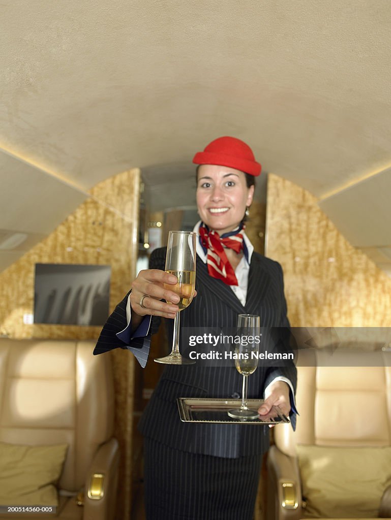 Flight attendant serving champagne, portrait