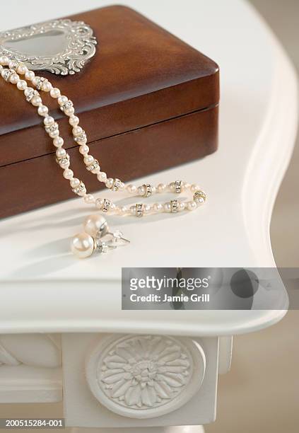 pearl necklace and earrings on wooden jewellery box, close-up, cropped - pearl earring stockfoto's en -beelden