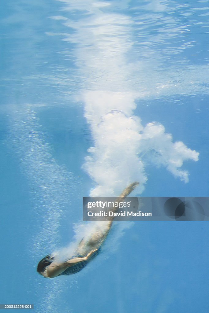 Female diver in pool, underwater view, (blurred motion)