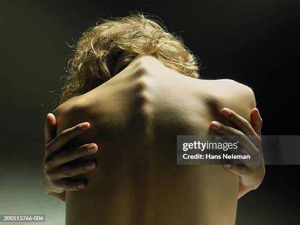 naked young woman embracing self, close-up, rear view - hugging self stock-fotos und bilder