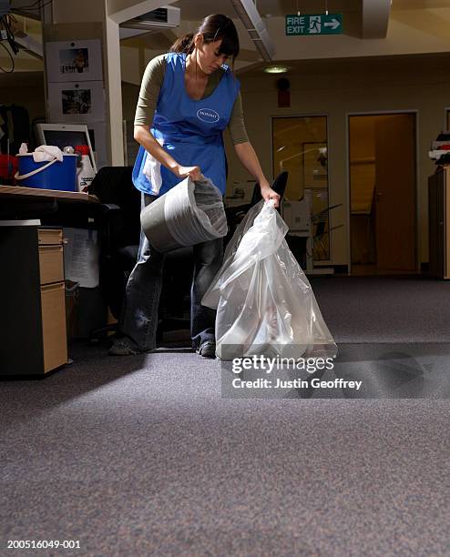 young female cleaner emptying rubbish bin in office - agent de ménage photos et images de collection
