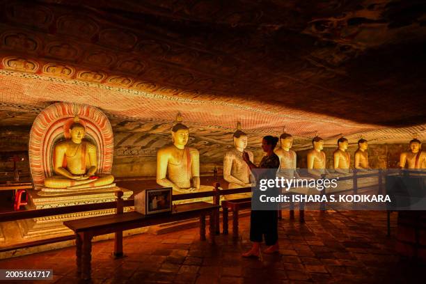 Foreign tourist take a picture of a Buddha statue while visiting the Rangiri Dambulla Cave Temple in Dambulla, some 150 Km north of Sri Lanka's...