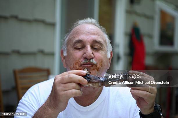 senior man eating steak, outdoors - männer grillen stock-fotos und bilder