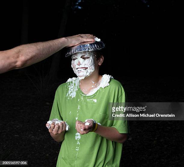 boy (10-11) getting cream pie in face, outdoors - pie in the face stock pictures, royalty-free photos & images