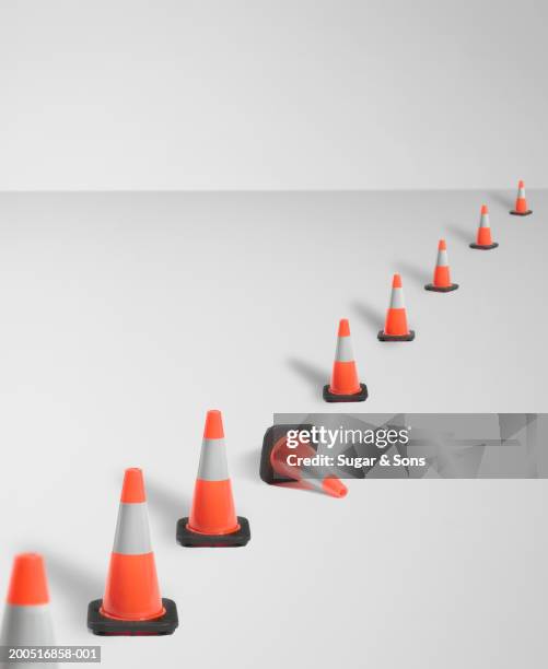 traffic safety cones with one knocked down (digital composite) - knocked down stock pictures, royalty-free photos & images