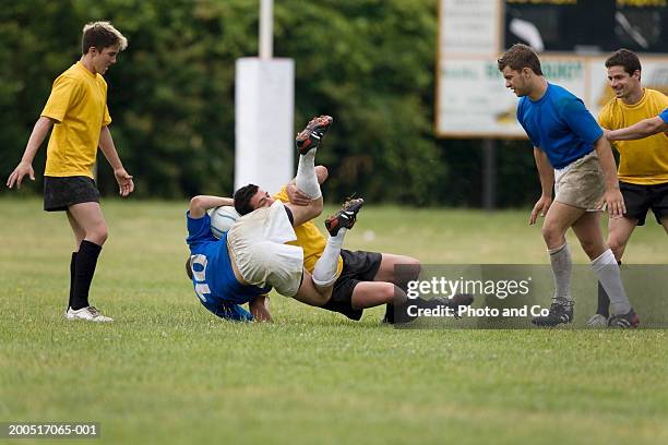 rugby player being tackled on pitch - althete fotografías e imágenes de stock